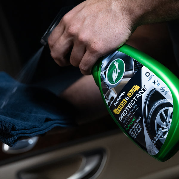 Detailing car interiors with Turtle Wax protectant, showing the running turtle logo on a green spray bottle. Car care product.