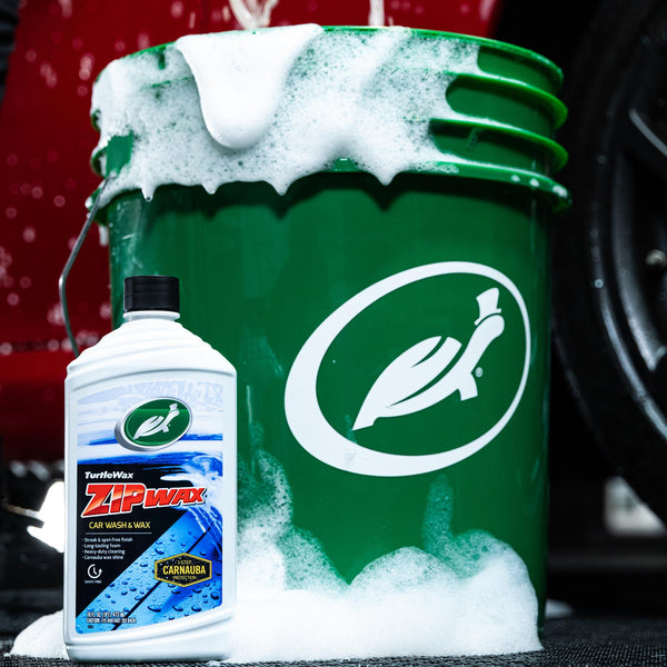 Turtle Wax Zip Wax bottle & green bucket of car wash soap suds. Auto detailing supplies for clean cars in USA.